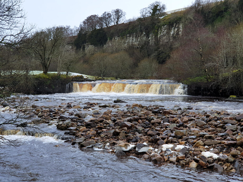 A highlight of this Yorkshire Dales waterfalls walk is Wain Wath Force, a low but wide waterfall under the shadow of rocky cliffs