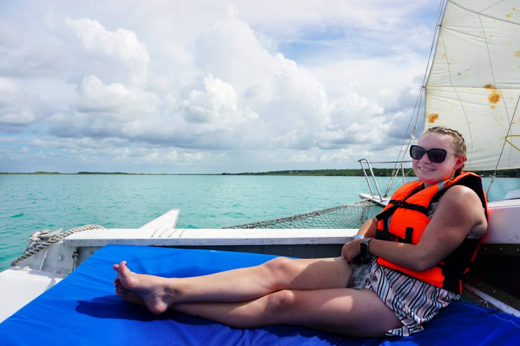 Zoe sat on a boat wearing a bright orange life jacket on Laguna Baclar
