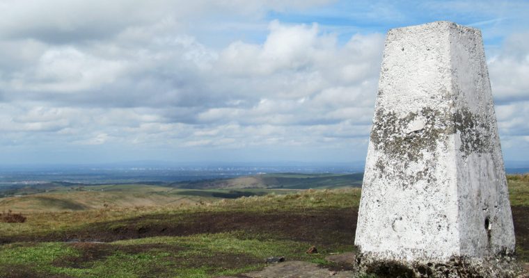 Looking north-west from the top of Shining Tor with Manchester in the background and the trig point in the foreground