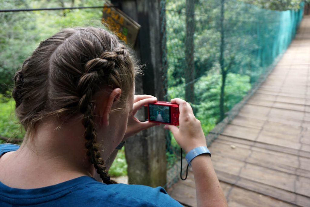 Zoe is photographed taking a photograph of a bridge in the El Arcotete EcoPark outside of San Cristobal. 