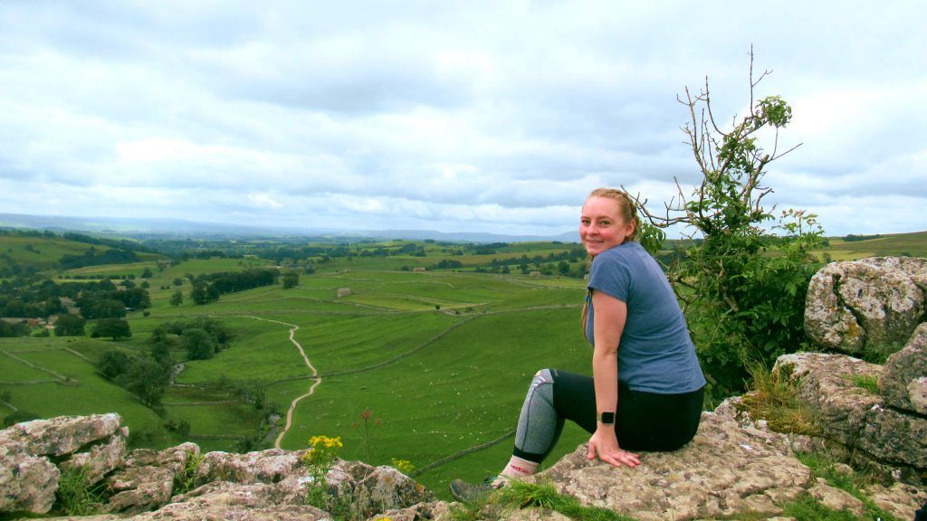 Zoe sat on top of Malham Cove looking out over the Yorkshire Dales