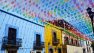 The beautiful streets of Oaxaca City, the capital of the state of Oaxaca. Colourful bunting hangs across the street of colourful buildings