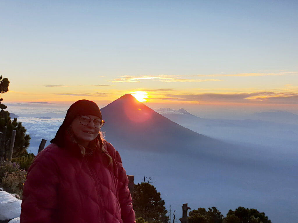 Zoe stood in front of Volcan Agua just as the sun peaks over the horizon