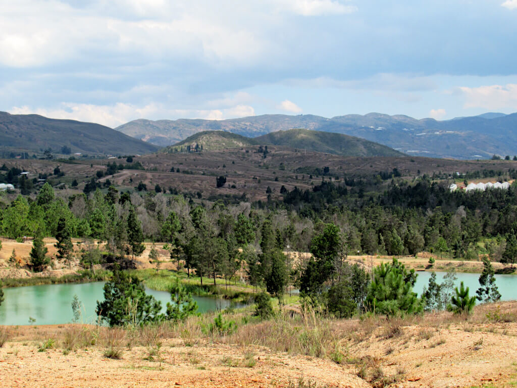 Two pools in the foreground with woodland and hills going far into the background