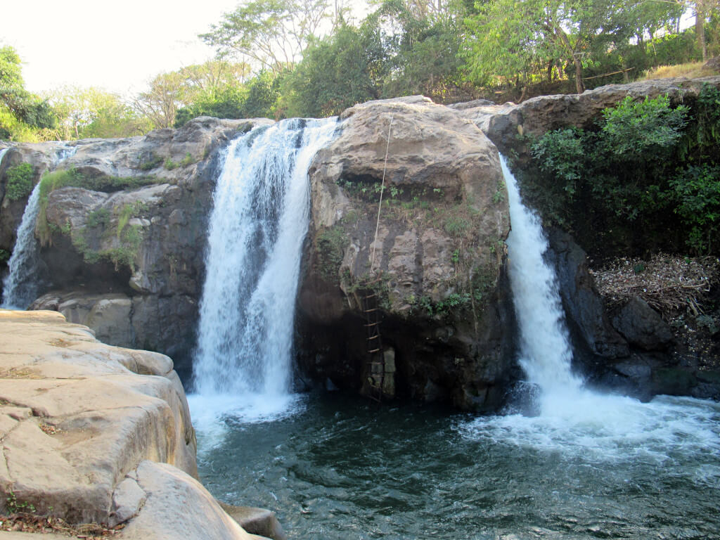 The hot water from the volcanic springs pouring over a rock edge creating a beautiful waterfall