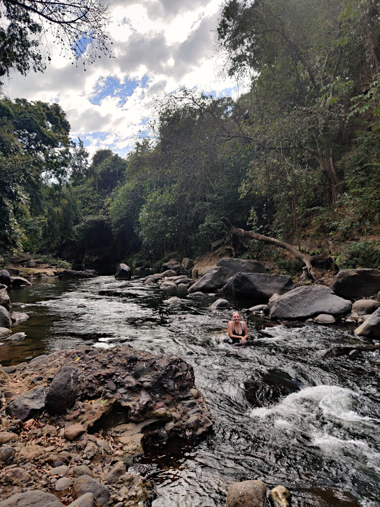 Zoe in the hot spring river surrounded by trees