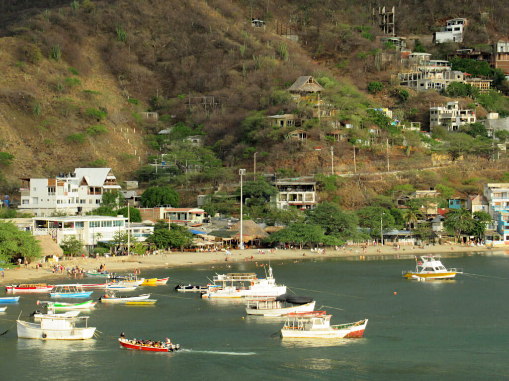 The thin beach lies at the bottom of the hills of the town with a few boats anchored in the water
