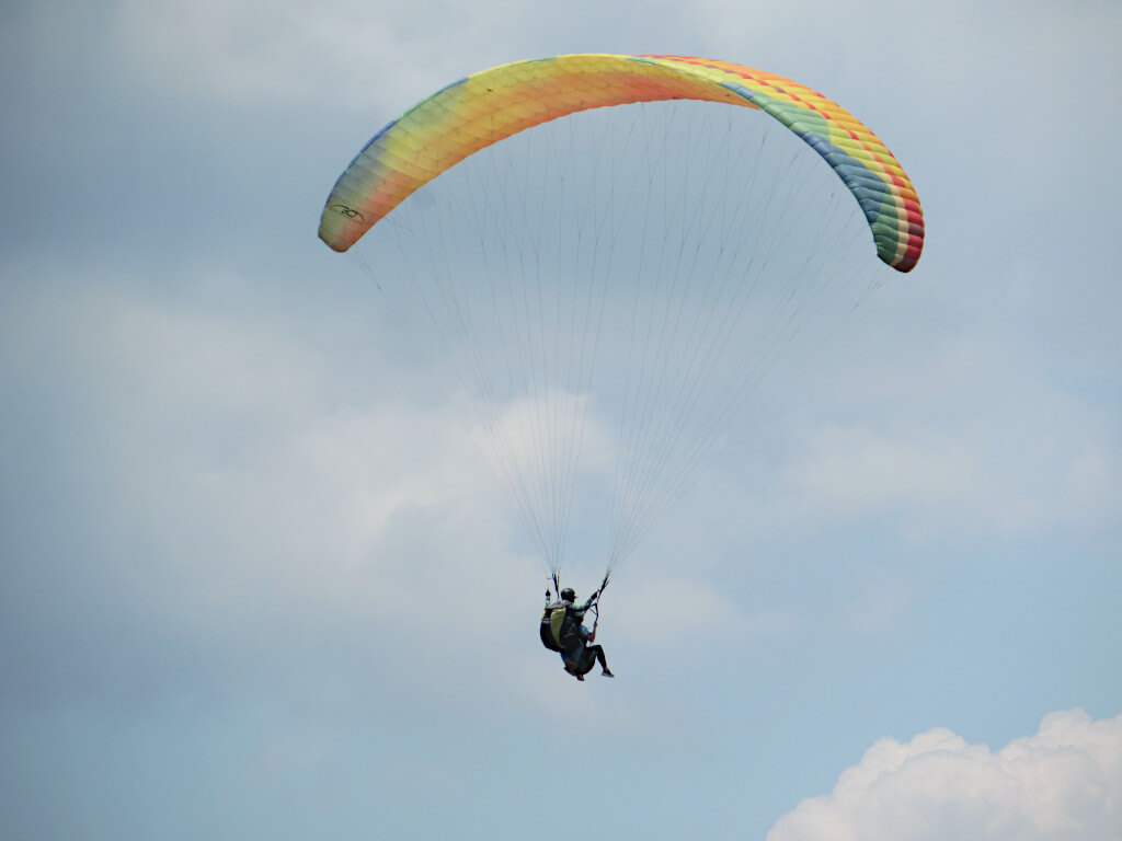 Paragliding over the Chicamocha Canyon against a cloudy blue sky