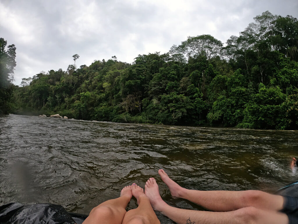 Gliding down the River over small rapids surrounded by trees