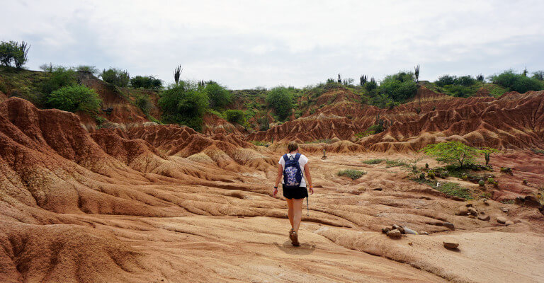 There are plenty of good hikes in Colombia. Zoe is pictured here walking in the Tatacoa Desert surrounded by bright red and orange rock