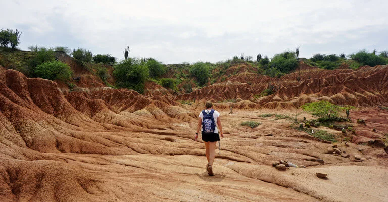 There are plenty of good hikes in Colombia. Zoe is pictured here walking in the Tatacoa Desert surrounded by bright red and orange rock