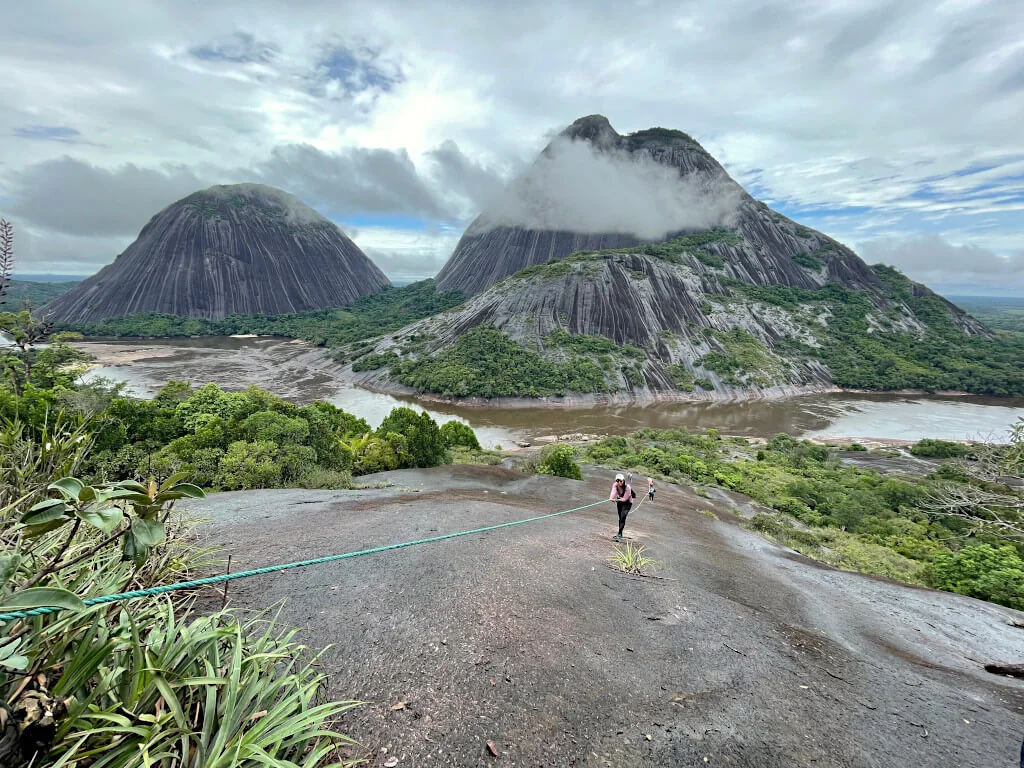 The Mavecure Hills in eastern Colombia are one of the most unique places to hike in Colombia. The hills (pictured) have striking white strips on the black rock, with grassy tops