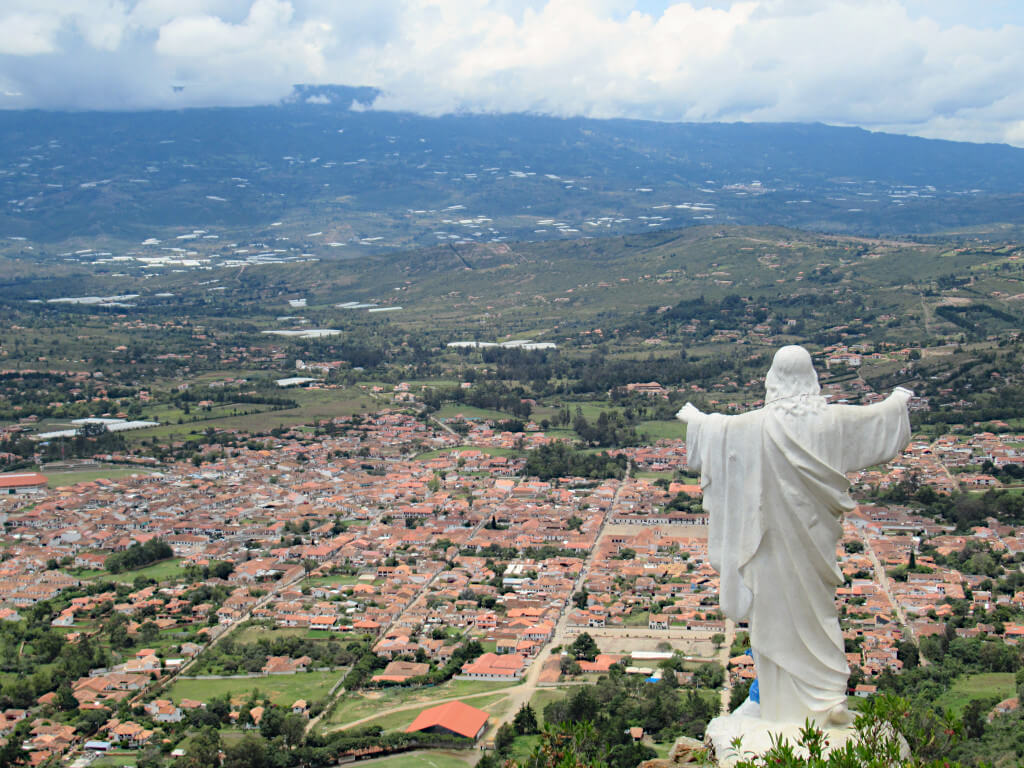 The view from the Villa de Leyva viewpoint including the statue of Jesus Christ and the distinctive orange roofs in the town