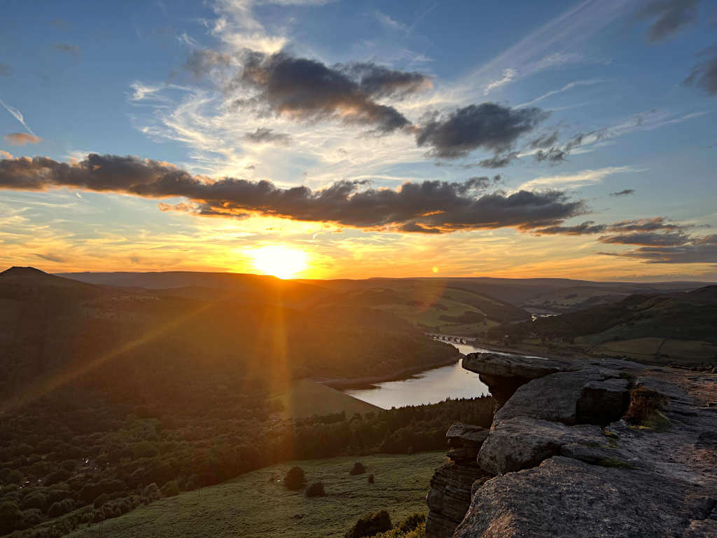 Looking over Ladybower Reservoir with Win Hill on the left, the sun sits just above the horizon