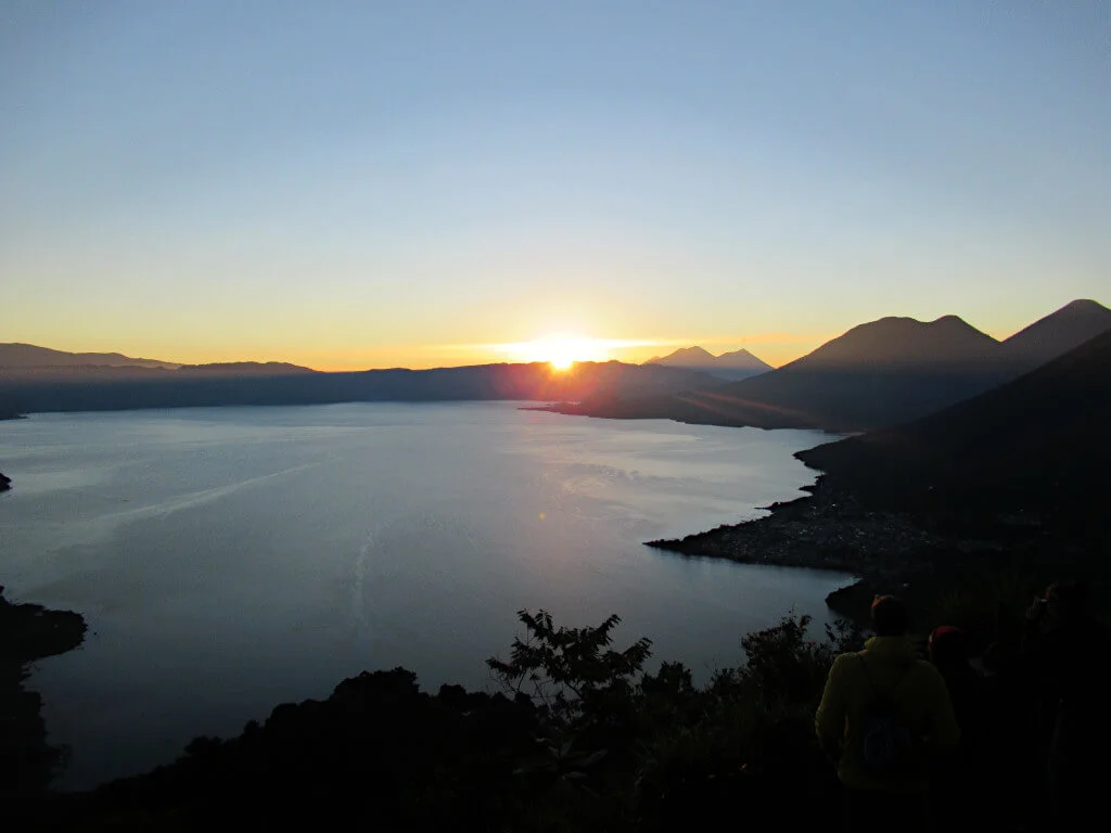 The sun creeps over the hills surrounding Lake Atitlan