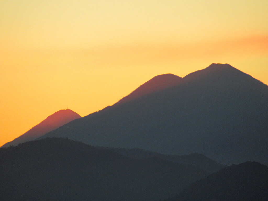 Acatenango Volcano from Indian Nose with a very orange sky and the volcanos as silhouettes