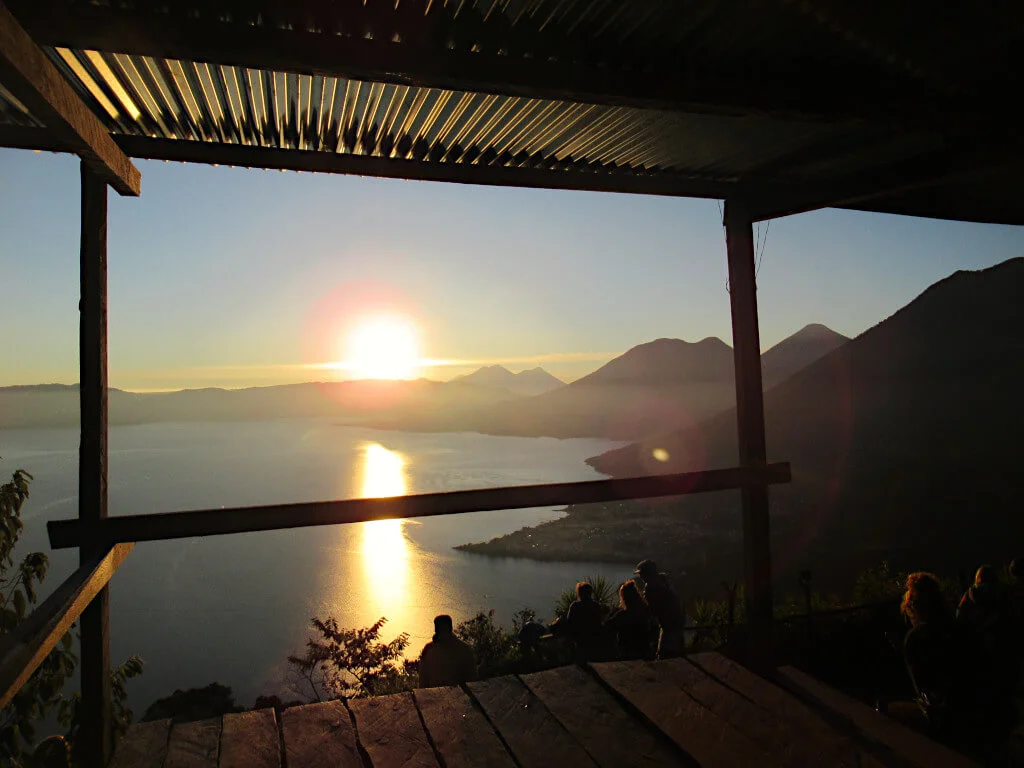 The sun rising in the sky over Lake Atitlan, seen from the viewpoint shelters on Indian Nose