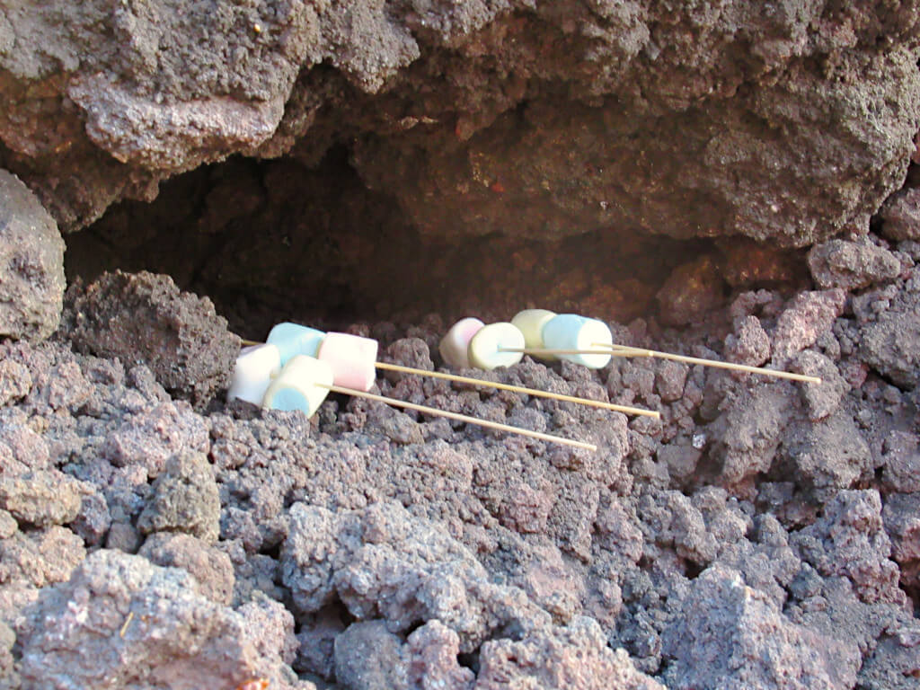 Marshmallows being heated on the hot volcanic rock