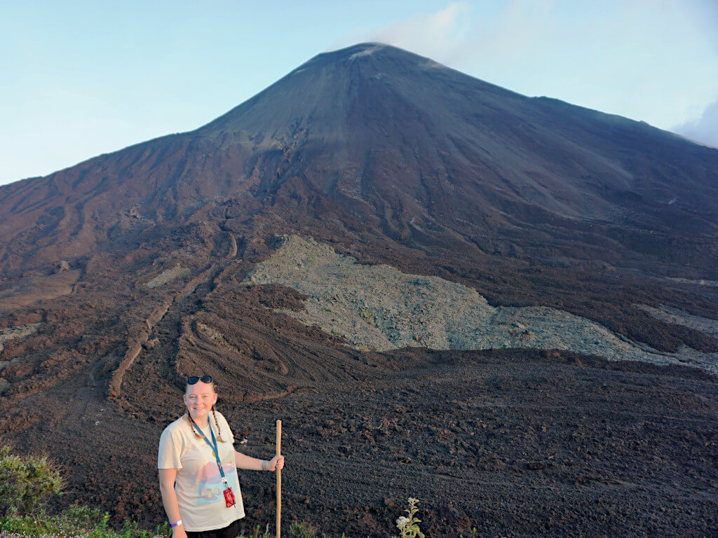 Zoe stood with Pacaya Guatemala behind her, traces of the old lava flows are visible but now there is just brown rock