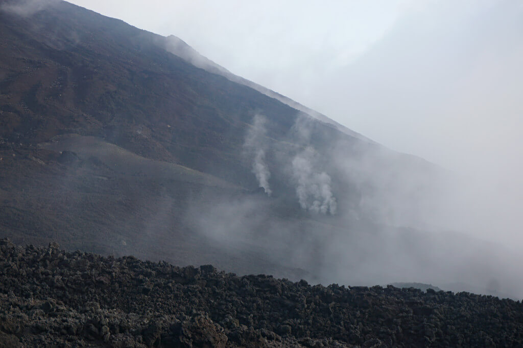 Steam rises from the hot volcanic rock on the lava fields of Pacaya Volcano
