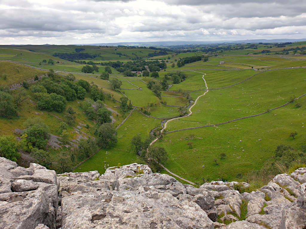 Looking towards Malham village from the top of Malham Cove with the path running through the centre of the image