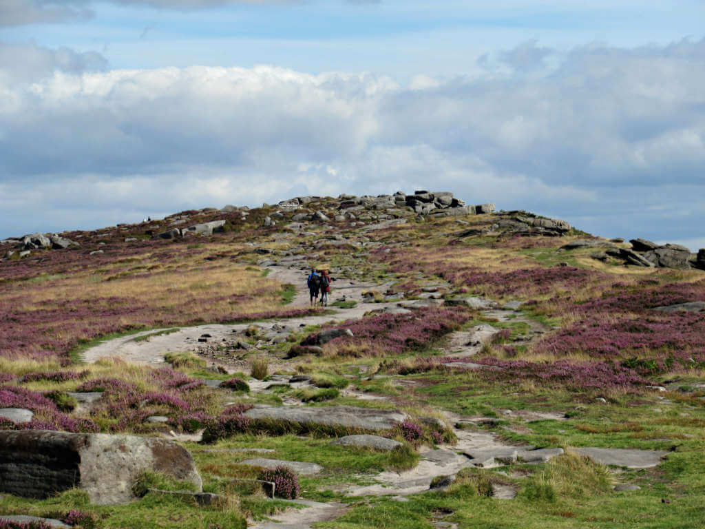 Two walkers approach the southern end of Stanage Edge