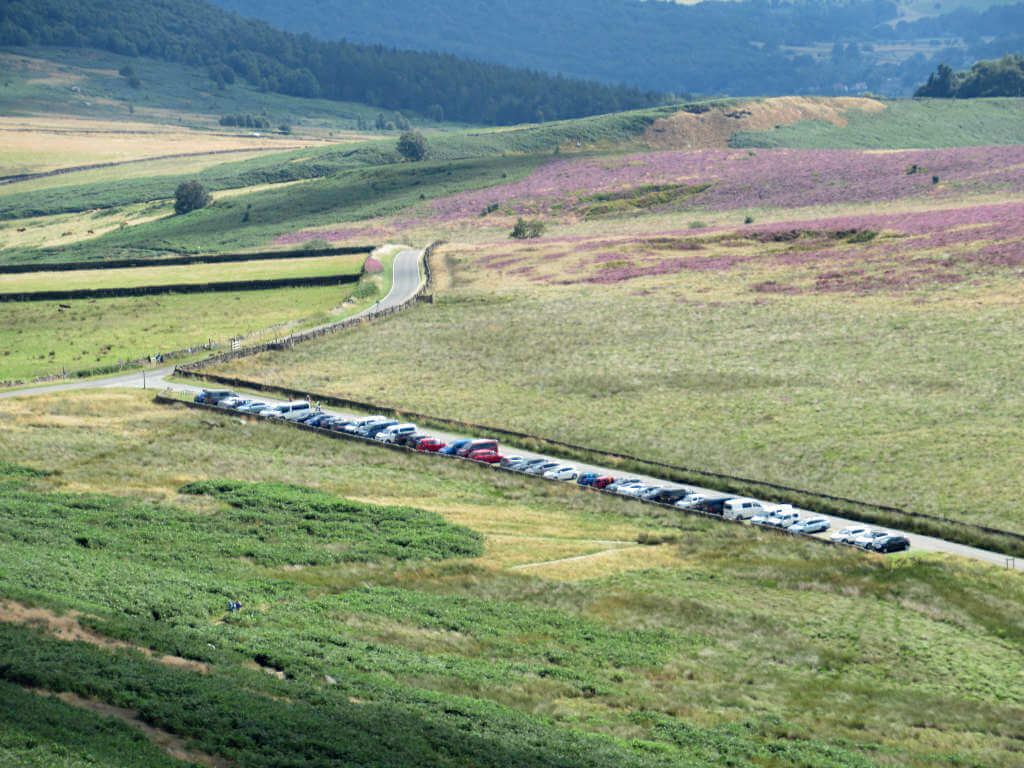 Cars line the car park on a sunny weekend