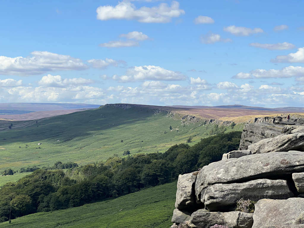 Looking along the ridgeline of Stanage Edge with rolling hills in the distance