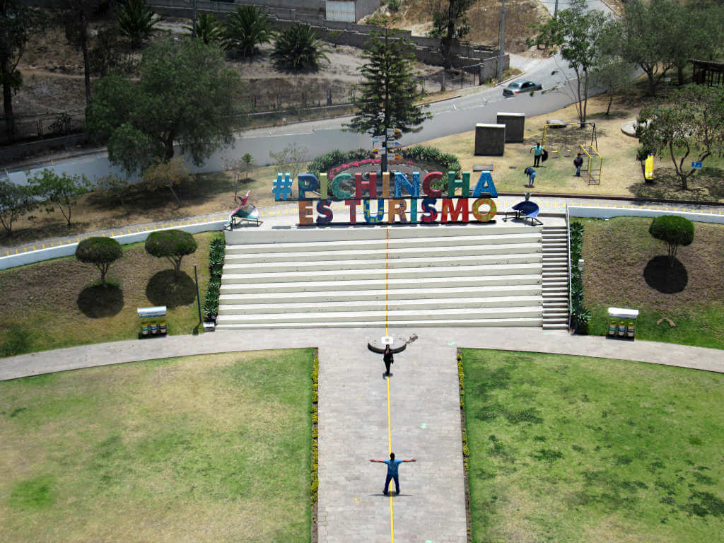 Looking down on the equator line where two people are taking photos from the top of the monument