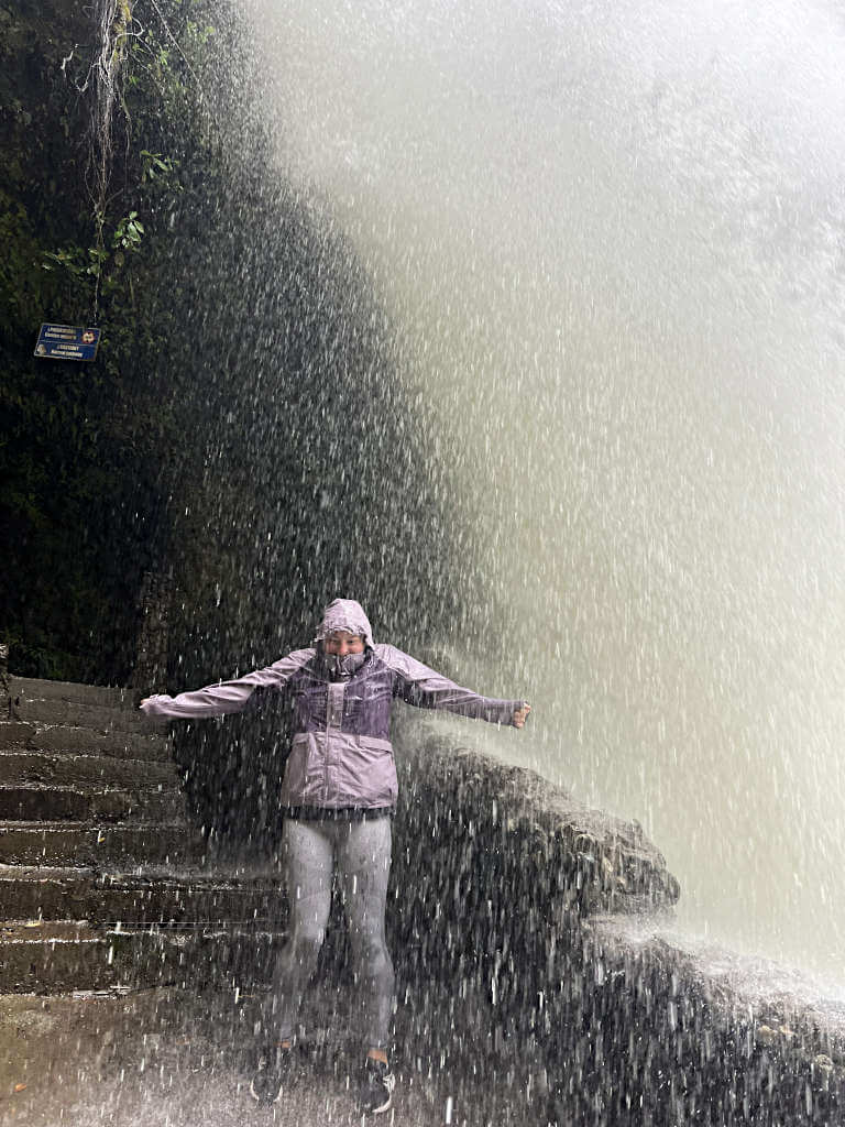 Zoe stood underneath the crashing waterfall on the viewing platform, water droplets rain down