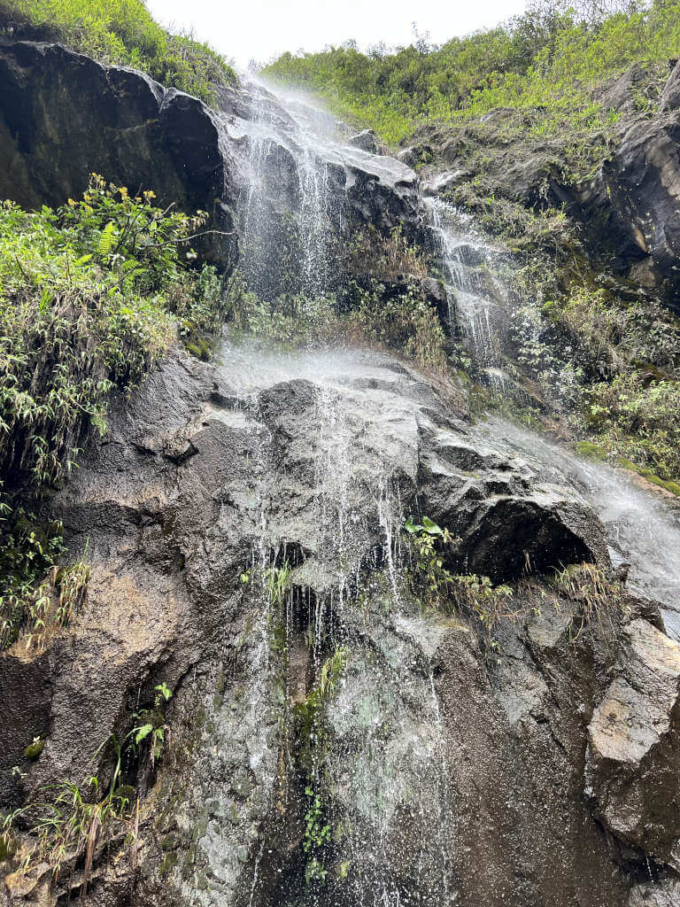 Looking up at a small waterfall located on the roadside on the Ruta de las Cascadas Banos