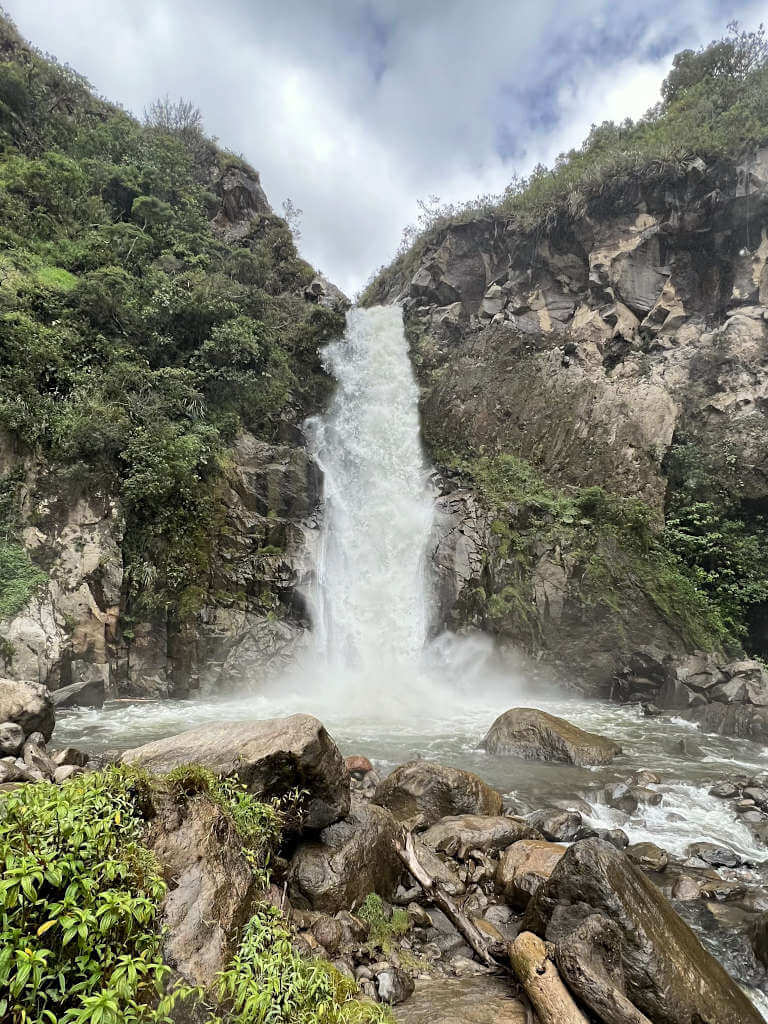 Cascada Ulba, the first main waterfall on the route from Banos. Water flows powerfully over the rock edge