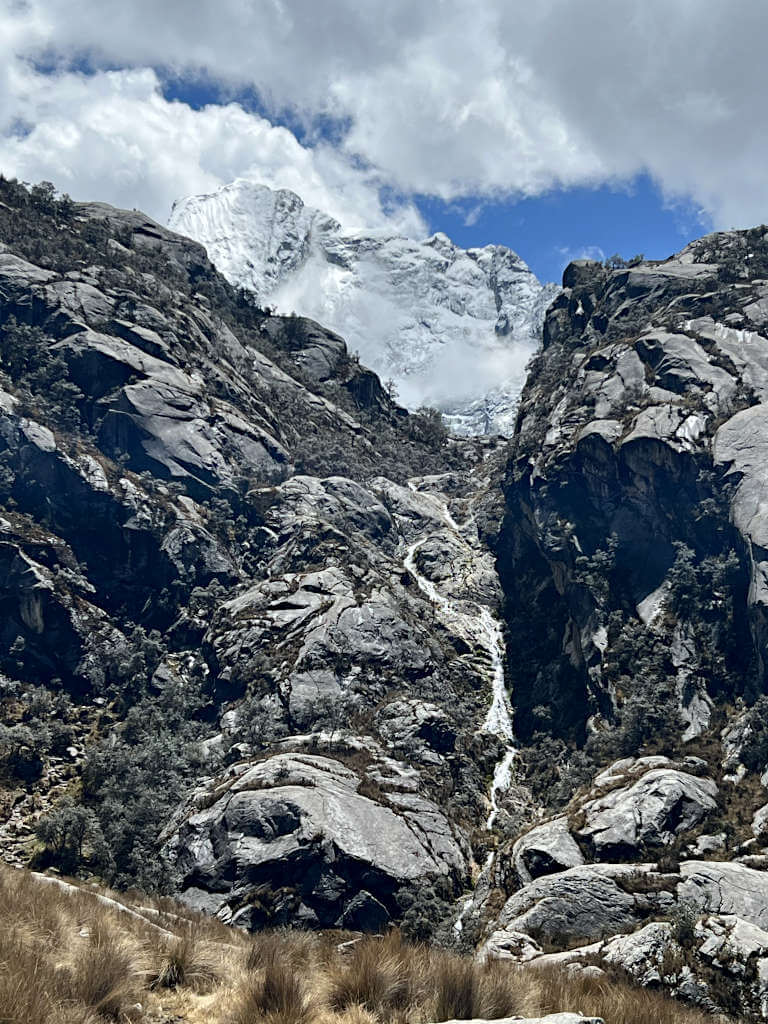 The difficult route to Churup takes you almost vertically up alongside the impressively tall waterfall, the snowy peak of Churup is behind
