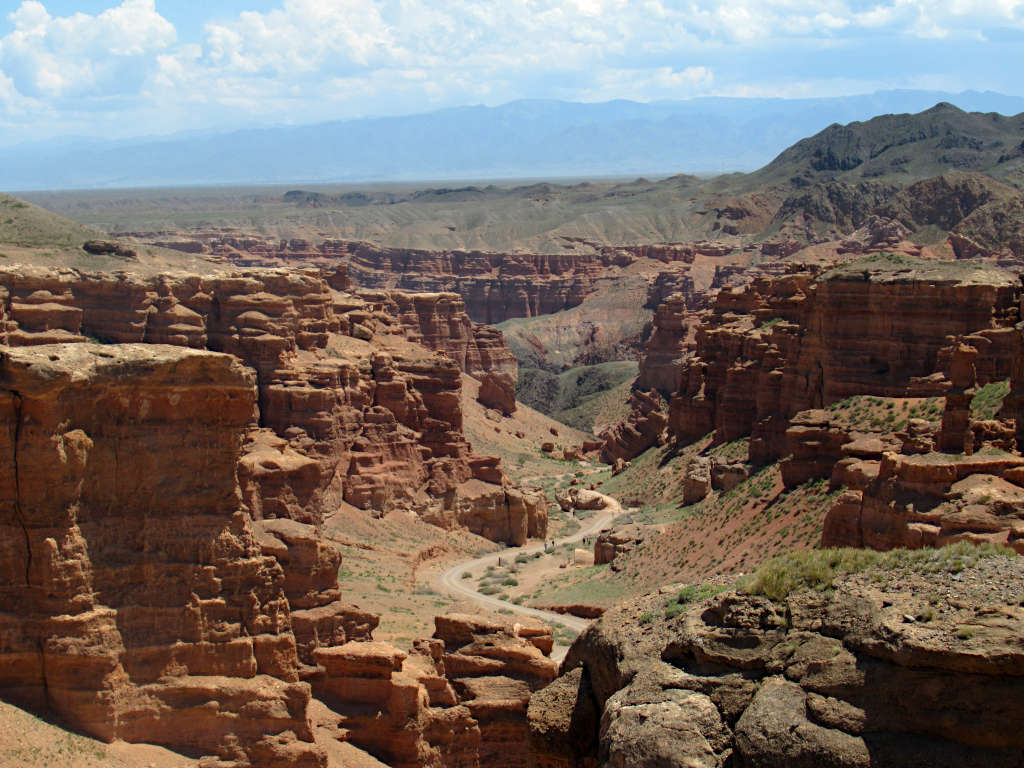 Looking through the Charyn Canyon in the south of Kazakhstan. Tall, layered rock stands vertically on either side