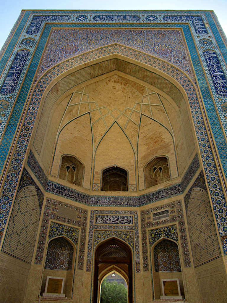 Looking up the facade of one of the many blue-coloured religious buildings in Uzbekistan. The best time to visit Uzbekistan is whenever you'll get to see impressive buildings like these!