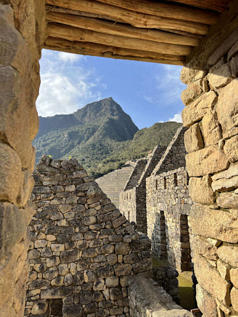 Machu Picchu Mountain towering over the ruins at this historic site, seen under the brick archway