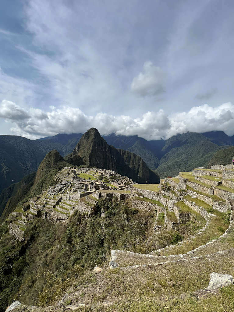 The tiered grass verges at Machu Picchu with Huayna Picchu behind with clouds looming in the background