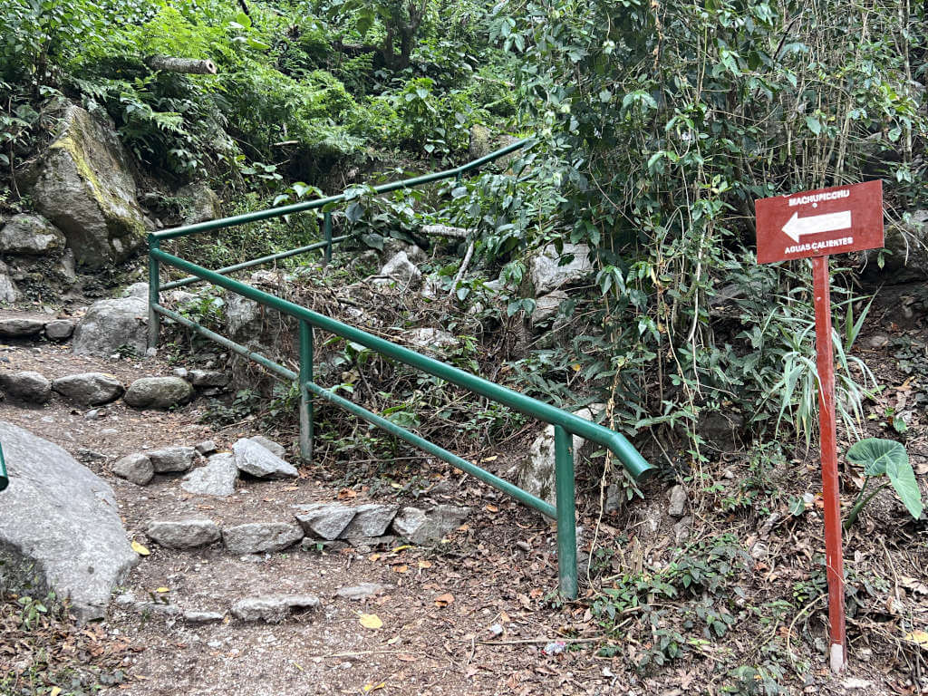 For a budget way of getting from Lima to Machu Picchu, take the bus from Cusco to Hidroelectrica. Then, hike for 2 hours alongside the train tracks. Follow signs like this to go in the right direction.