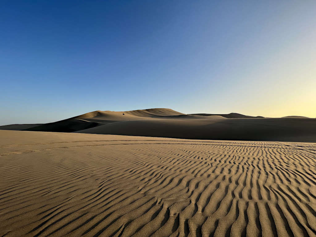 Travel from Lima to Machu Picchu via Huacachina, an oasis town in the middle of sand dunes.
