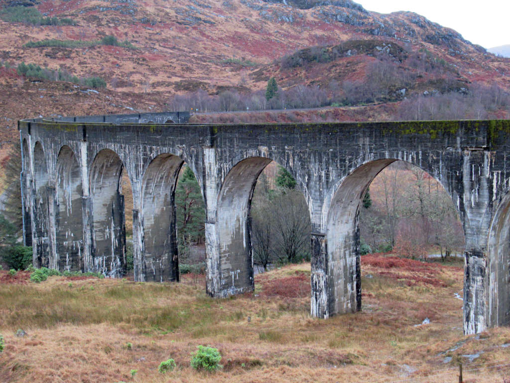 An up close shot of the viaduct with the red-brown colours of the hills behind
