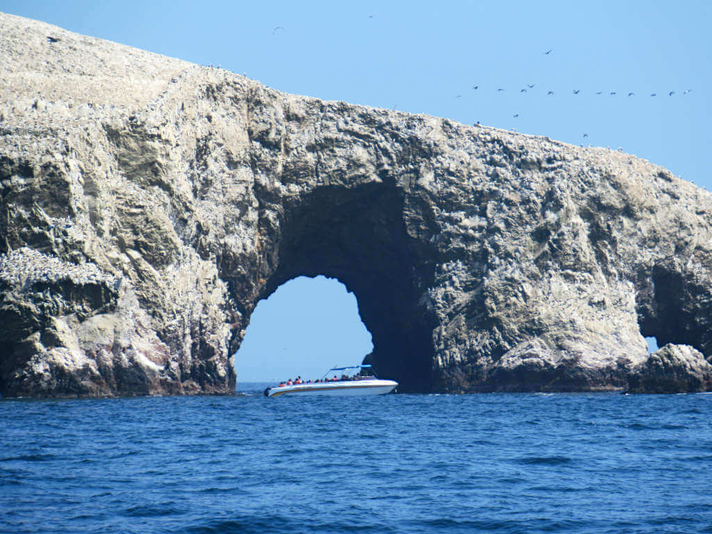 A boat tour of the Ballestas Islands with an arch through the rocky island