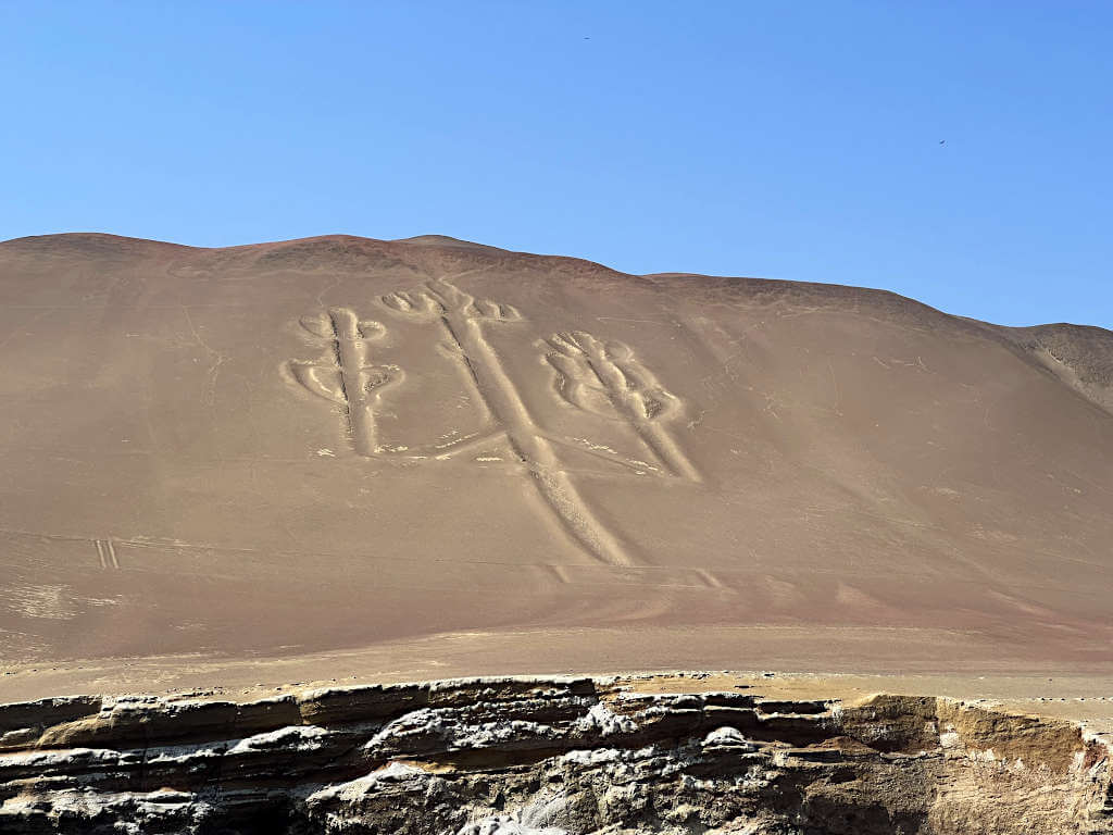 The candelabra geoglyph viewed from sea, carved into the stone ground of the hillside
