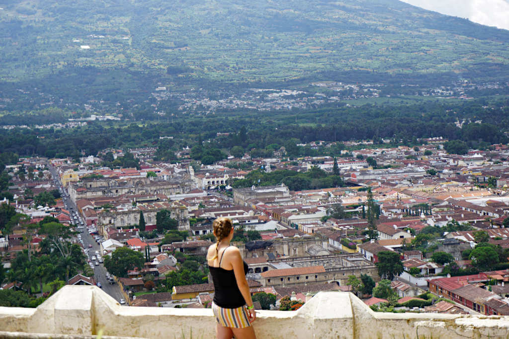 Zoe stood at the Tres Cruces viewpoint in Antigua Guatemala with the city behind