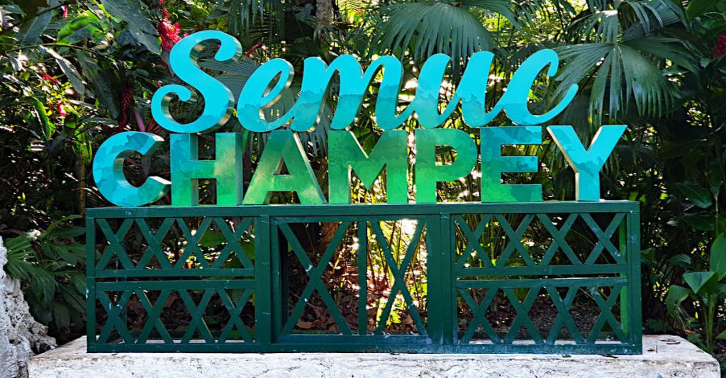 A green and blue cursive sign that reads 'Semuc Champey'