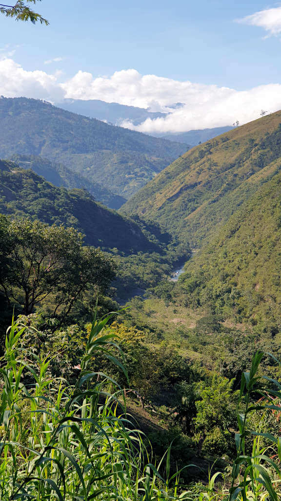A scenic rest stop on the journey through Guatemala. A river meanders through the narrow valley with tree-covered hills rising steeply