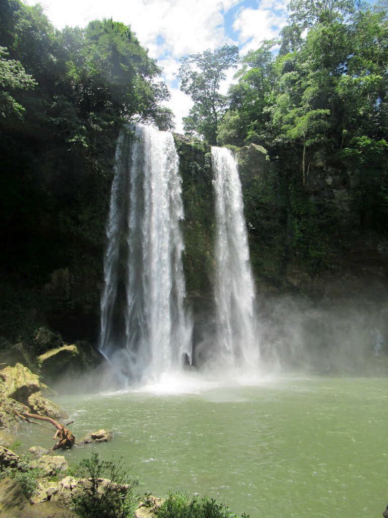 Cascada Misol-Ha near Palenque in Mexico - a tall waterfall plunges into a large pool surrounded by trees