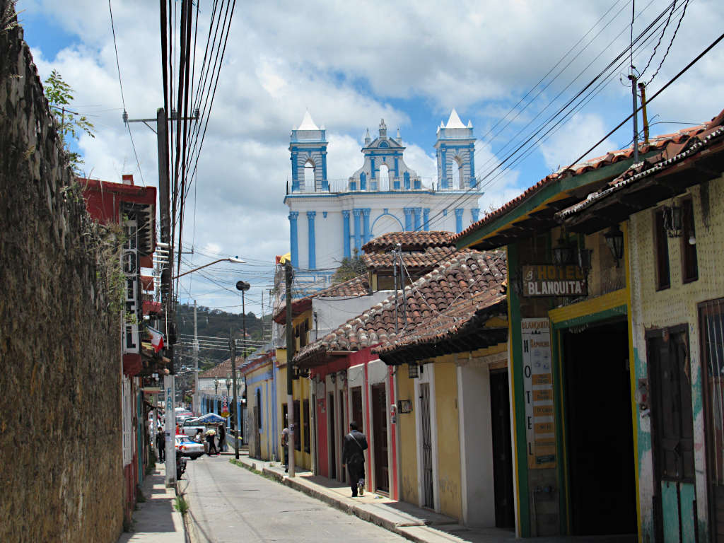 The colourful single-storey buildings of San Cristobal de las Casas with a striking blue and white church sticking out behind