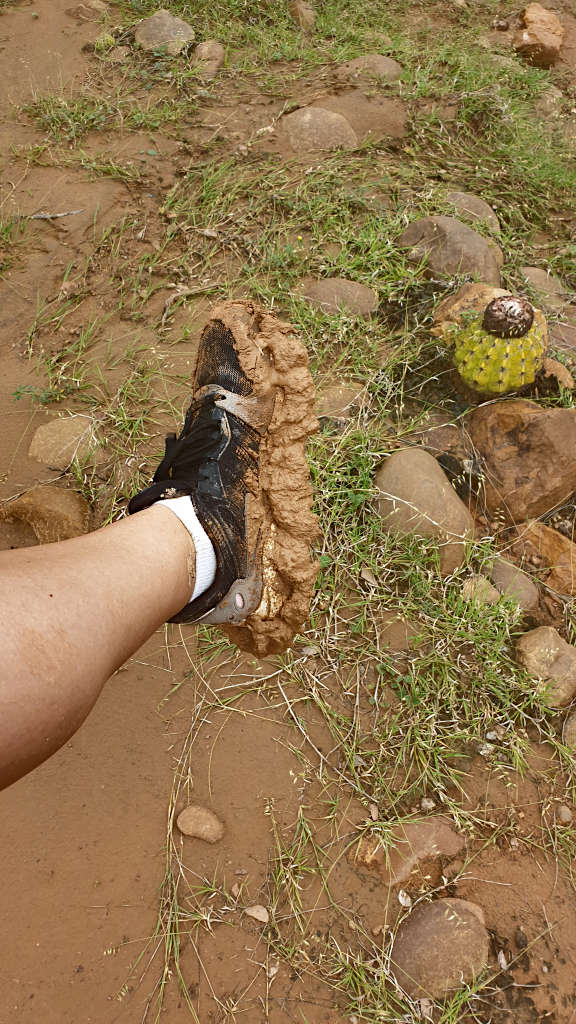 Walking through the wet mud in the Tatacoa Desert, large clumps of mud are stuck to the bottom of the shoes