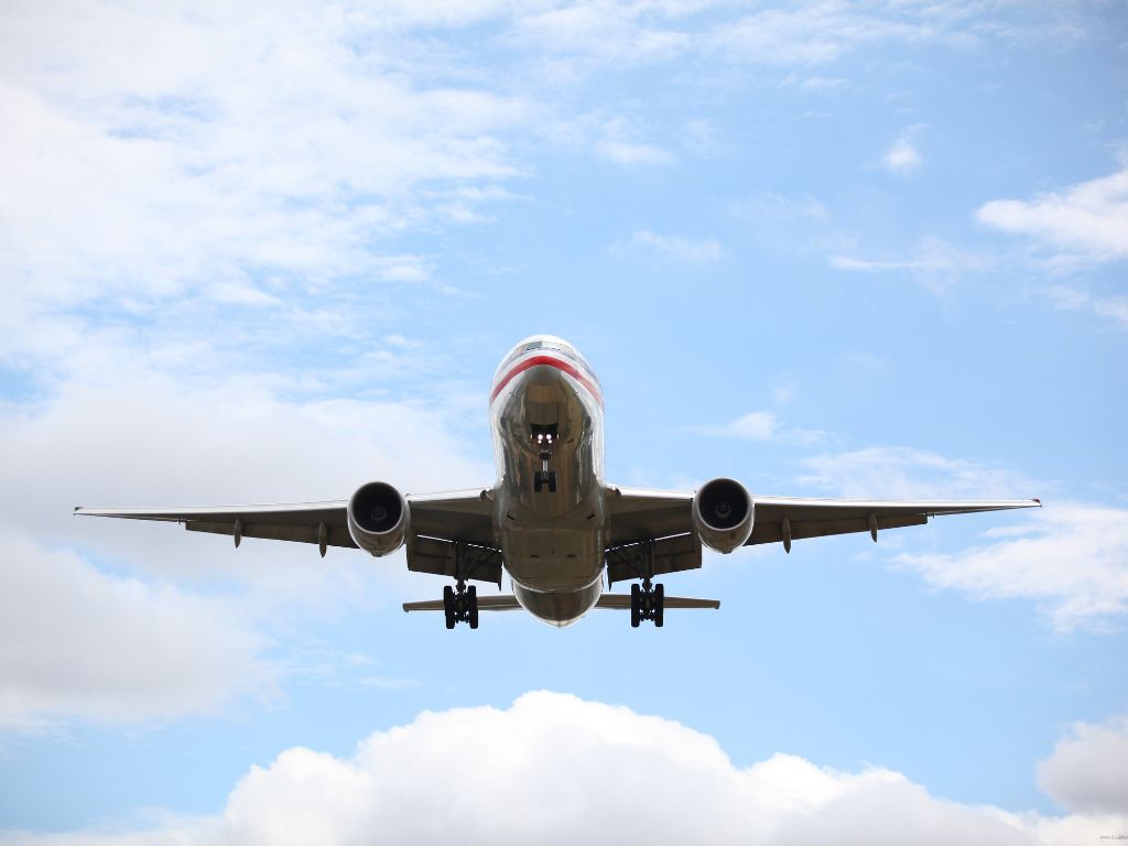 Looking up at a plane in the blue sky as it flys overhead