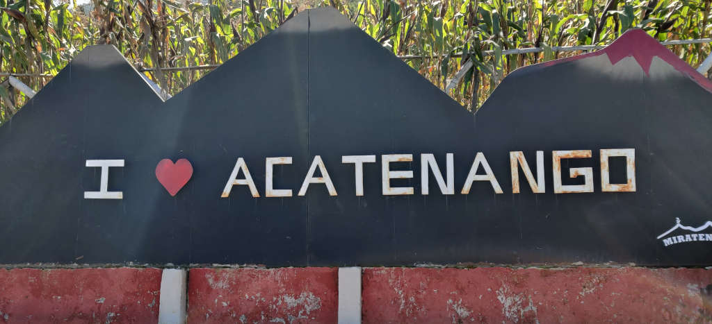 I sign that reads 'I heart Acatenango' on a background of 3 volcanoes